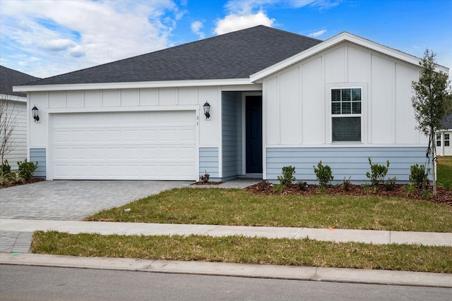 ranch-style home featuring a front lawn and a garage