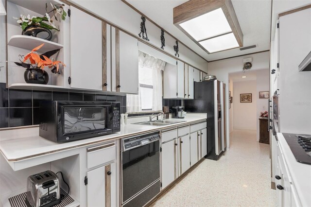 kitchen featuring black appliances, white cabinetry, backsplash, and sink