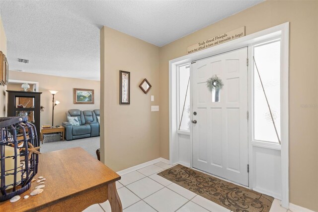 tiled entrance foyer featuring a textured ceiling