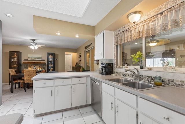 kitchen with ceiling fan, kitchen peninsula, light tile patterned flooring, and white cabinets