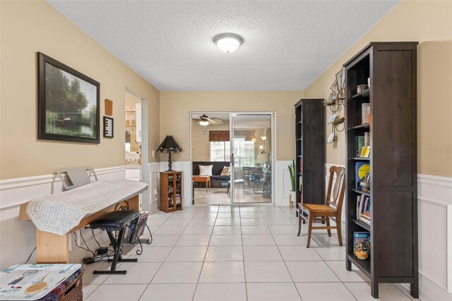 tiled office with ceiling fan and a textured ceiling