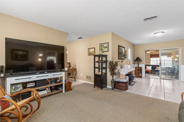 living room with a textured ceiling and light carpet