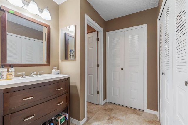 bathroom featuring tile patterned flooring, a textured ceiling, and vanity