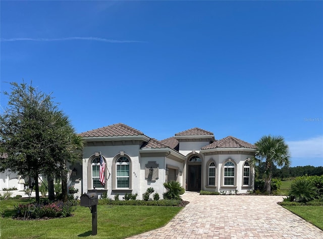 mediterranean / spanish-style home with a front yard