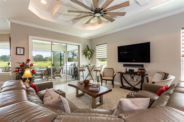 tiled living room featuring ceiling fan, crown molding, and a tray ceiling