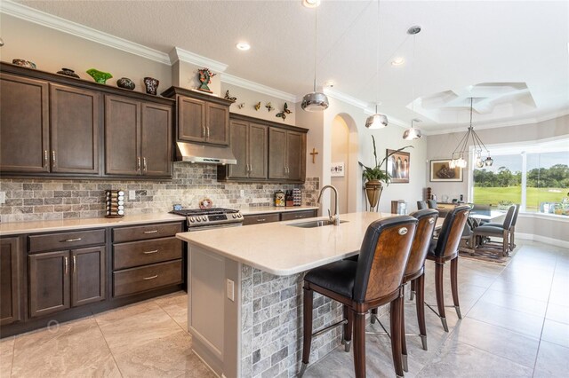 kitchen with backsplash, sink, hanging light fixtures, and dark brown cabinets