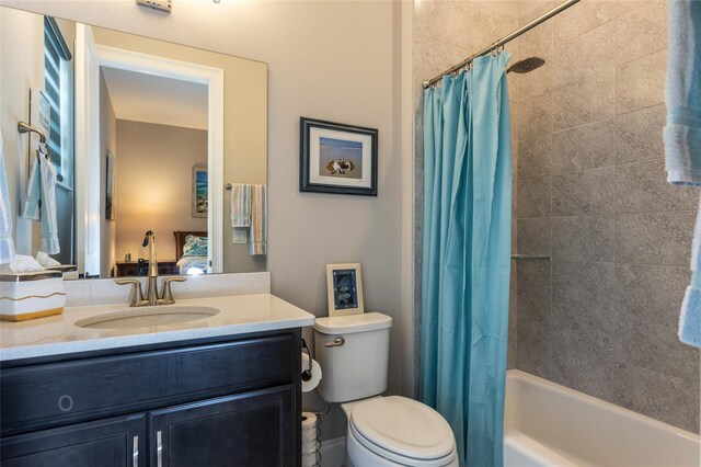 full bathroom featuring shower / bath combo with shower curtain, vanity, and toilet