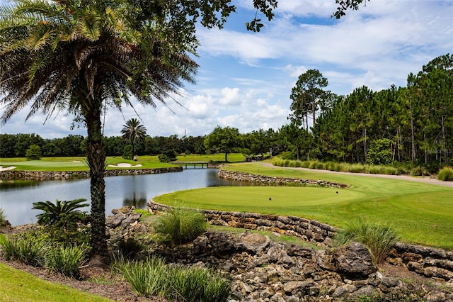 view of property's community featuring a lawn, a water view, and view of golf course