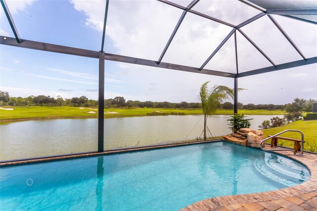 view of swimming pool with a lawn and a water view