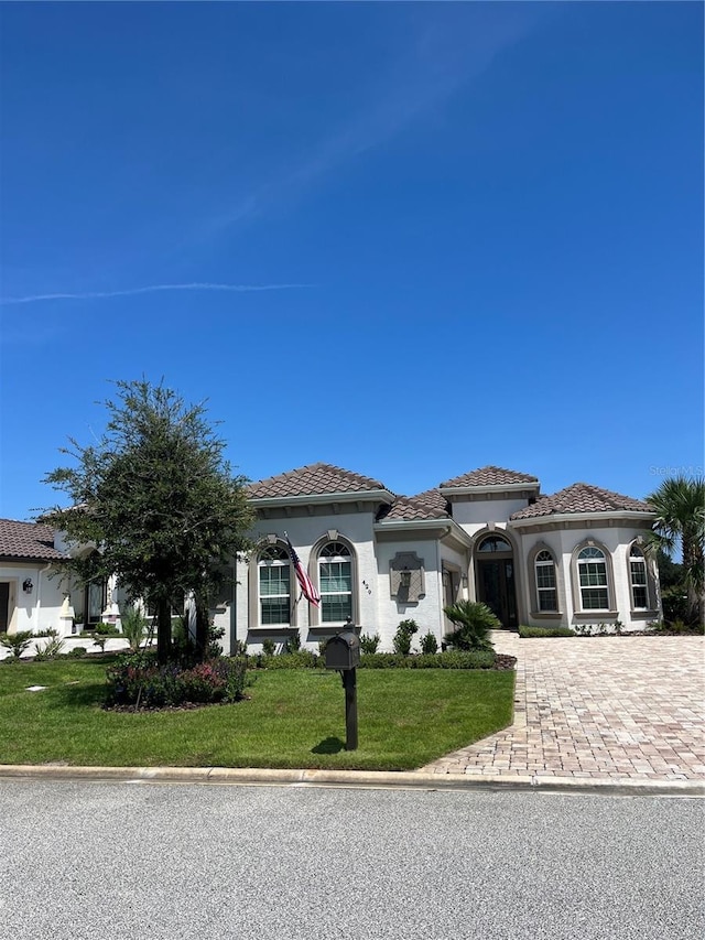 mediterranean / spanish-style house featuring a front yard