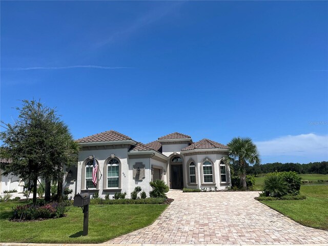 mediterranean / spanish-style home featuring a front yard