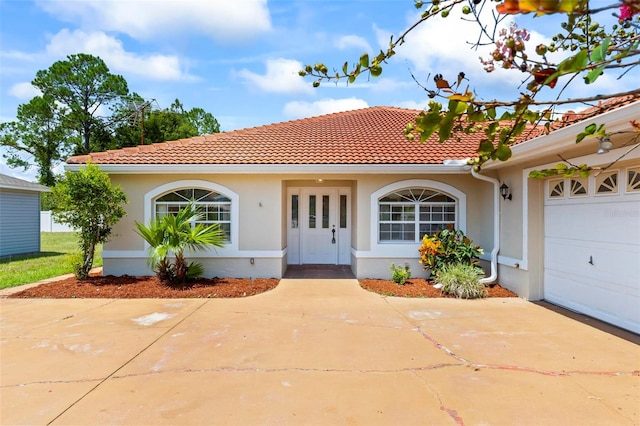 mediterranean / spanish-style home with a garage