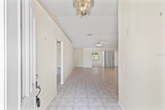 corridor with a notable chandelier and light tile patterned flooring