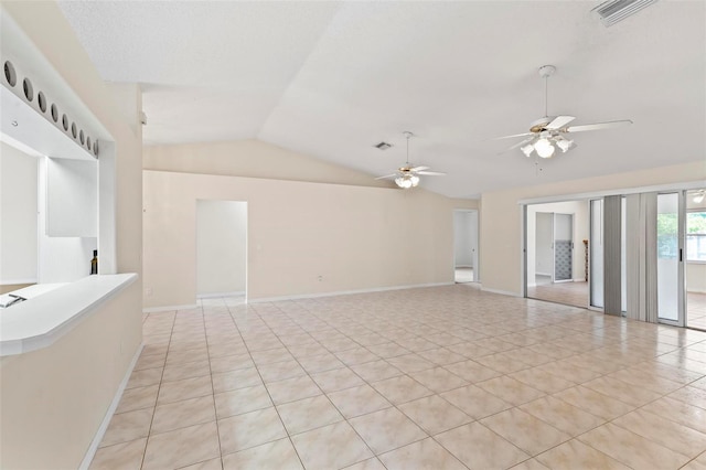 tiled empty room featuring ceiling fan and lofted ceiling