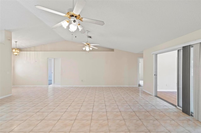 tiled spare room with vaulted ceiling and ceiling fan with notable chandelier