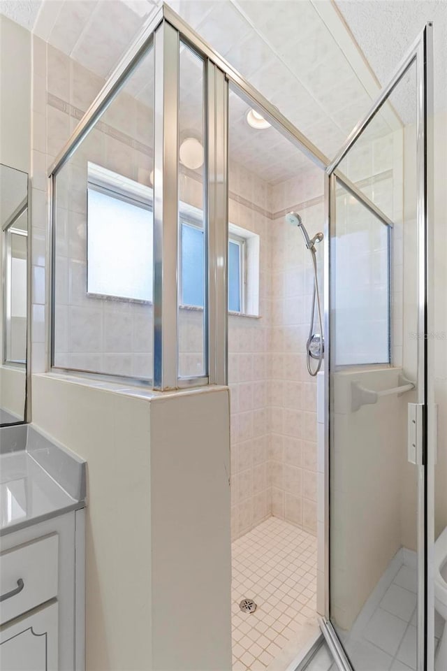 bathroom with an enclosed shower, vanity, and toilet