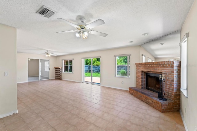 unfurnished living room featuring ceiling fan, a brick fireplace, lofted ceiling, and light tile patterned flooring