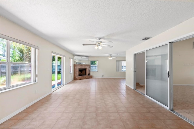 unfurnished living room featuring ceiling fan, a fireplace, a textured ceiling, and light tile patterned floors