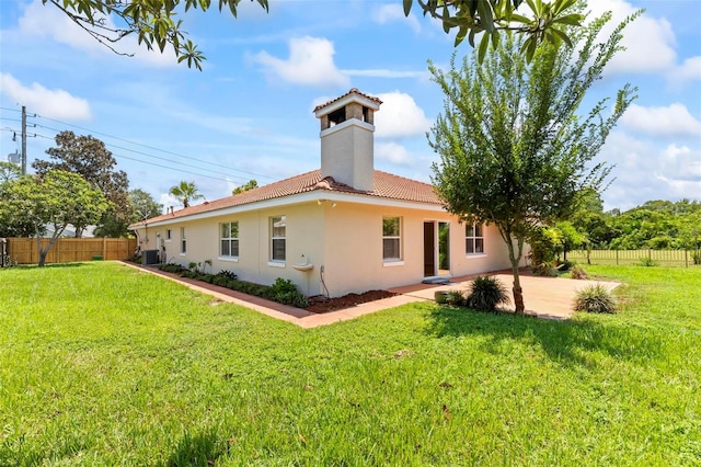 back of property featuring central AC, a patio area, and a yard