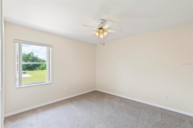 carpeted spare room with ceiling fan and a textured ceiling