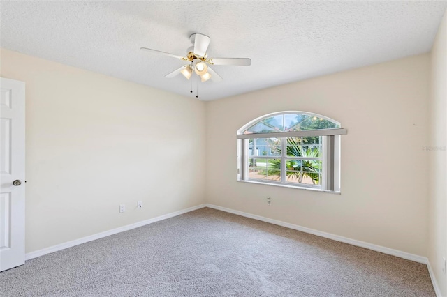 empty room with ceiling fan, carpet, and a textured ceiling