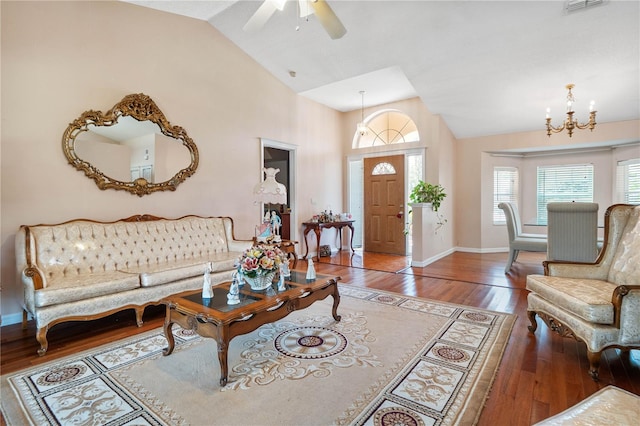 living room with high vaulted ceiling, hardwood / wood-style floors, and ceiling fan with notable chandelier