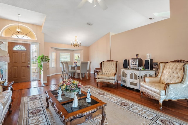 living room featuring ceiling fan with notable chandelier, vaulted ceiling, and hardwood / wood-style flooring