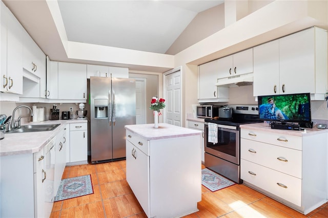 kitchen with stainless steel appliances, sink, vaulted ceiling, and white cabinetry