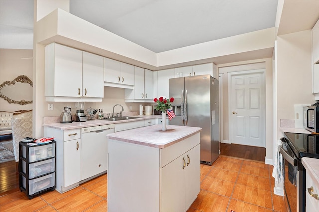 kitchen with a kitchen island, light hardwood / wood-style flooring, white appliances, and white cabinets