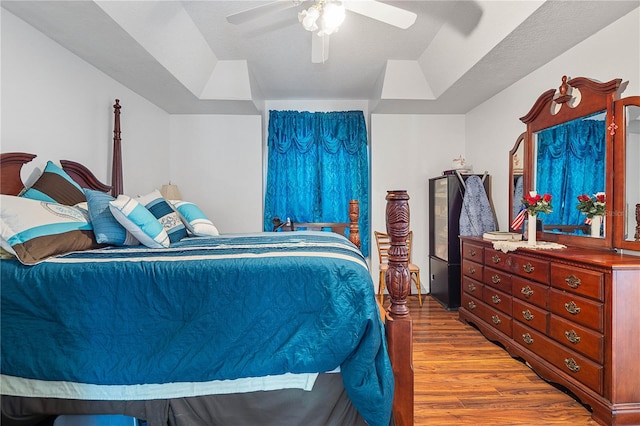 bedroom with ceiling fan, wood-type flooring, and a textured ceiling