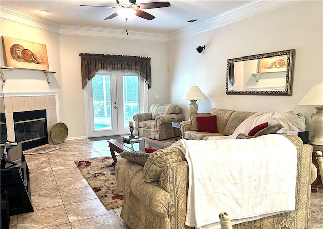 tiled living room featuring a tile fireplace, ceiling fan, french doors, a textured ceiling, and ornamental molding