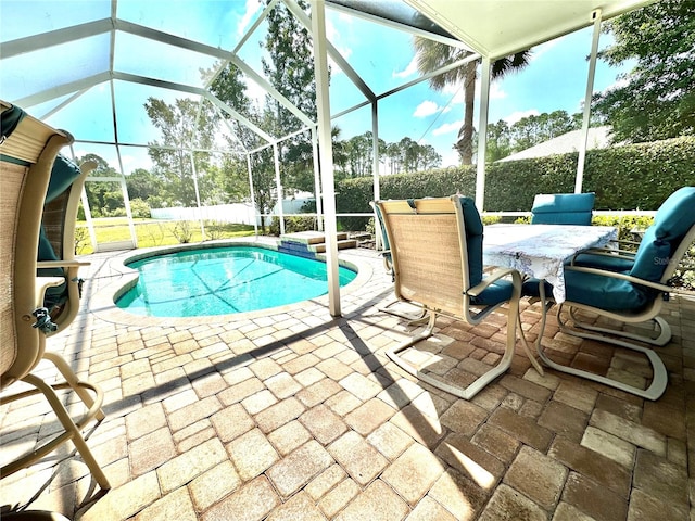 view of pool with glass enclosure and a patio