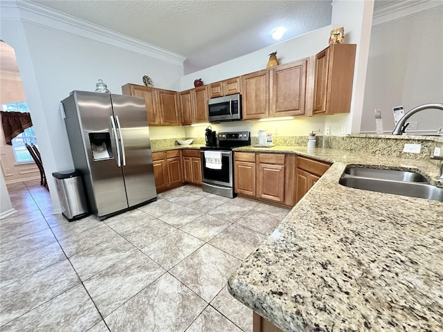 kitchen with kitchen peninsula, appliances with stainless steel finishes, crown molding, and sink