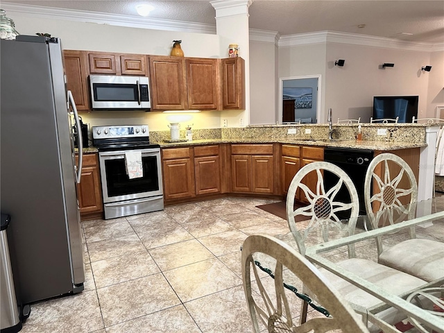 kitchen with sink, light stone counters, kitchen peninsula, crown molding, and appliances with stainless steel finishes