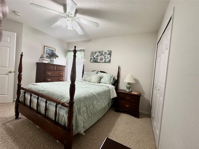 carpeted bedroom featuring ceiling fan, a closet, and a textured ceiling