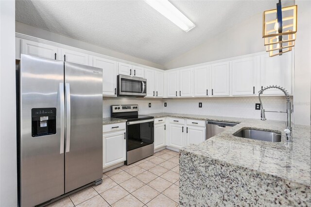 kitchen with appliances with stainless steel finishes, sink, pendant lighting, white cabinets, and light tile patterned floors