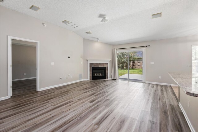 unfurnished living room with a fireplace, a textured ceiling, and dark hardwood / wood-style flooring