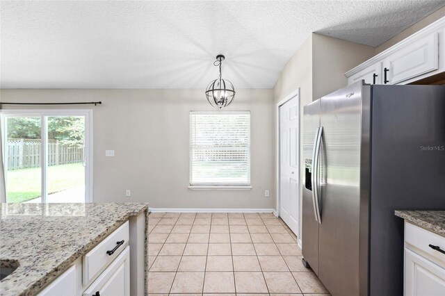 kitchen featuring light tile patterned floors, an inviting chandelier, white cabinetry, stainless steel fridge, and pendant lighting