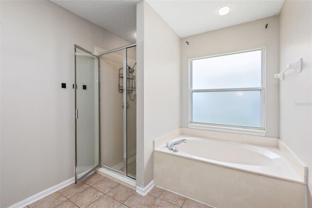 bathroom featuring a wealth of natural light, plus walk in shower, tile patterned floors, and a textured ceiling