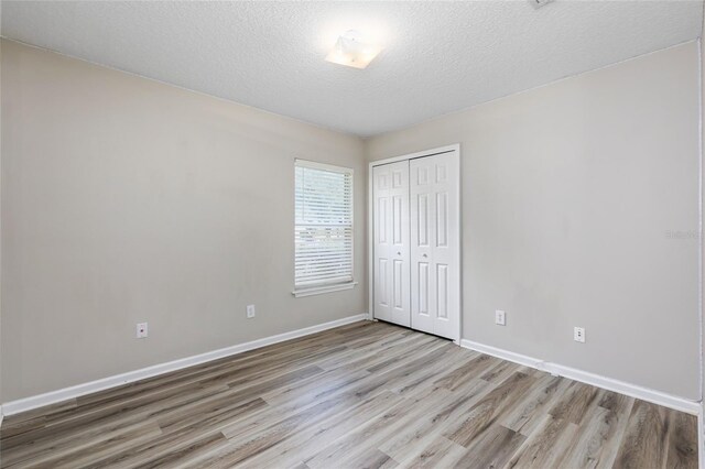 unfurnished room featuring a textured ceiling and wood-type flooring