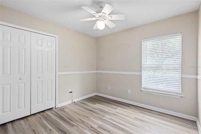 unfurnished bedroom featuring ceiling fan, a closet, and light hardwood / wood-style floors