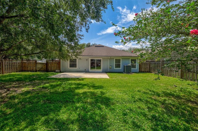 back of house featuring central AC, a patio area, and a yard