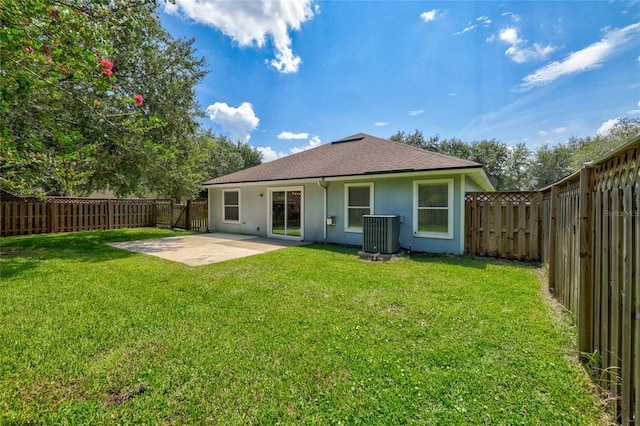 rear view of house with a patio area, a yard, and central AC