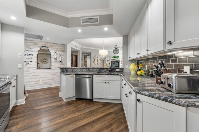 kitchen featuring white cabinets, kitchen peninsula, dark wood-type flooring, and stainless steel appliances