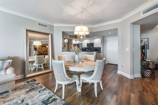 dining space with dark hardwood / wood-style flooring, an inviting chandelier, and crown molding