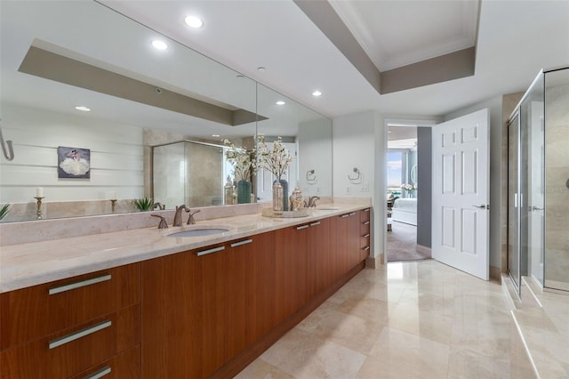 bathroom with ornamental molding, double vanity, tile patterned flooring, a raised ceiling, and a shower with door