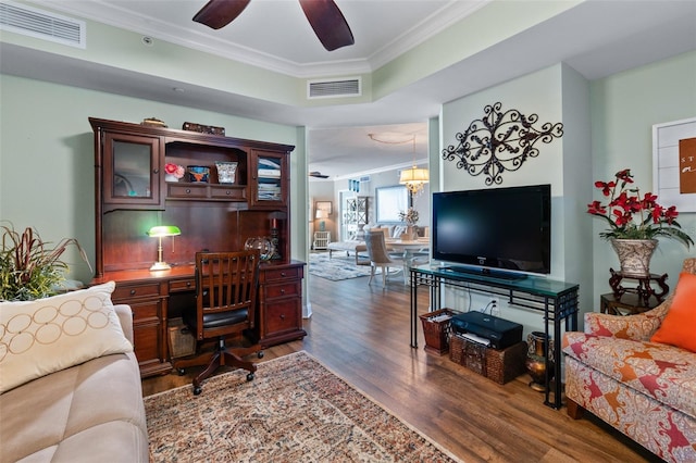 living room featuring hardwood / wood-style flooring, ceiling fan with notable chandelier, and ornamental molding