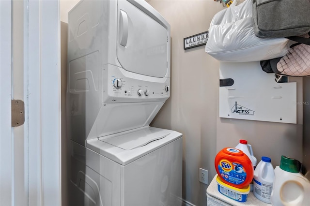 clothes washing area with stacked washing maching and dryer