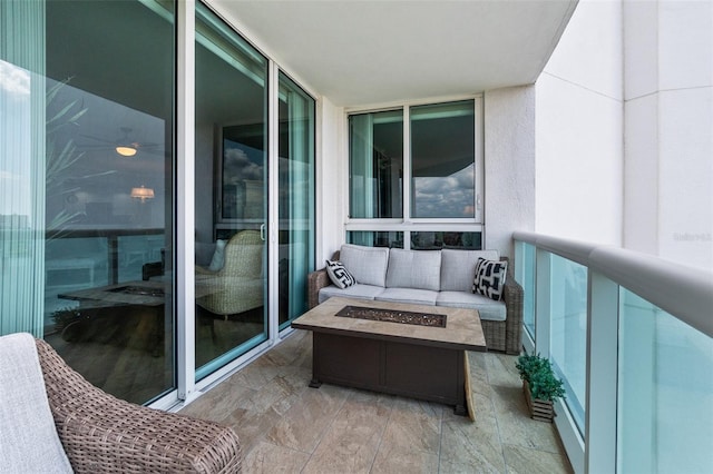 balcony featuring an outdoor living space with a fire pit