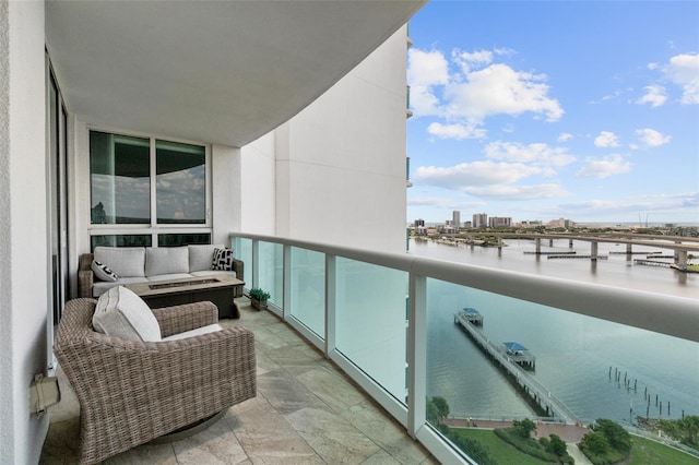 balcony with outdoor lounge area and a water view